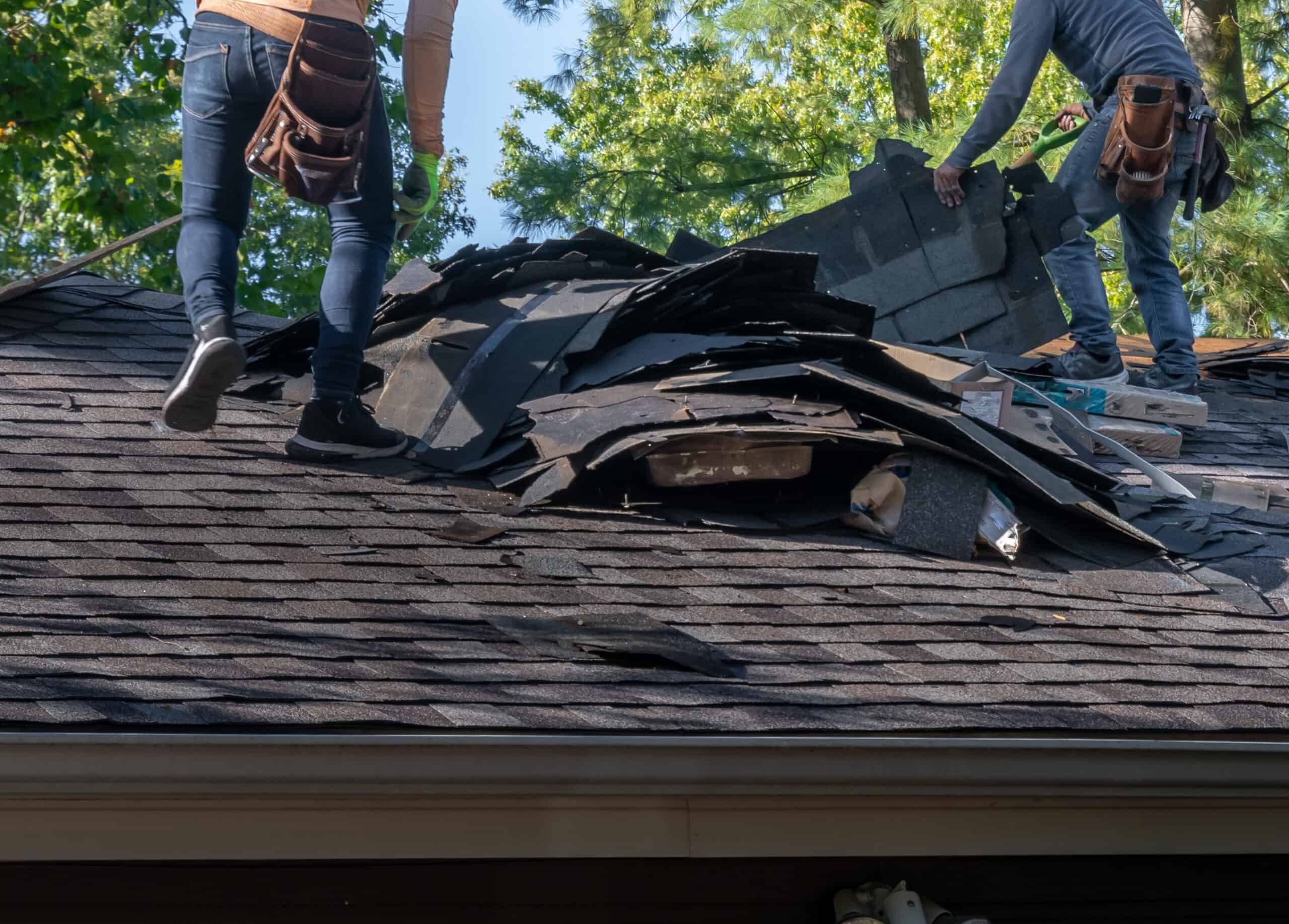 A roofer and a customer talking outside of a house.