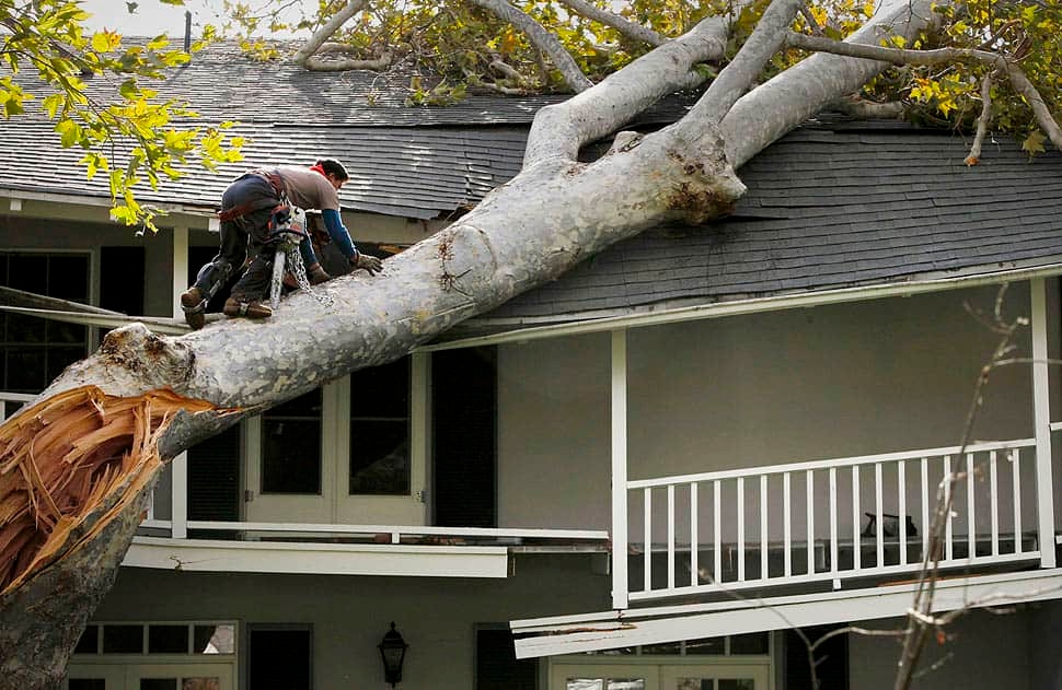 A roofer and a customer talking outside of a house.