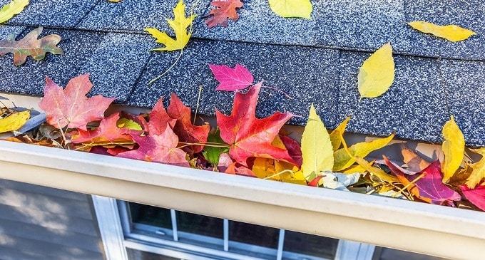 A roofer and a customer talking outside of a house.