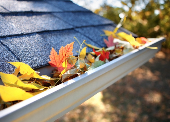 A roofer and a customer talking outside of a house.