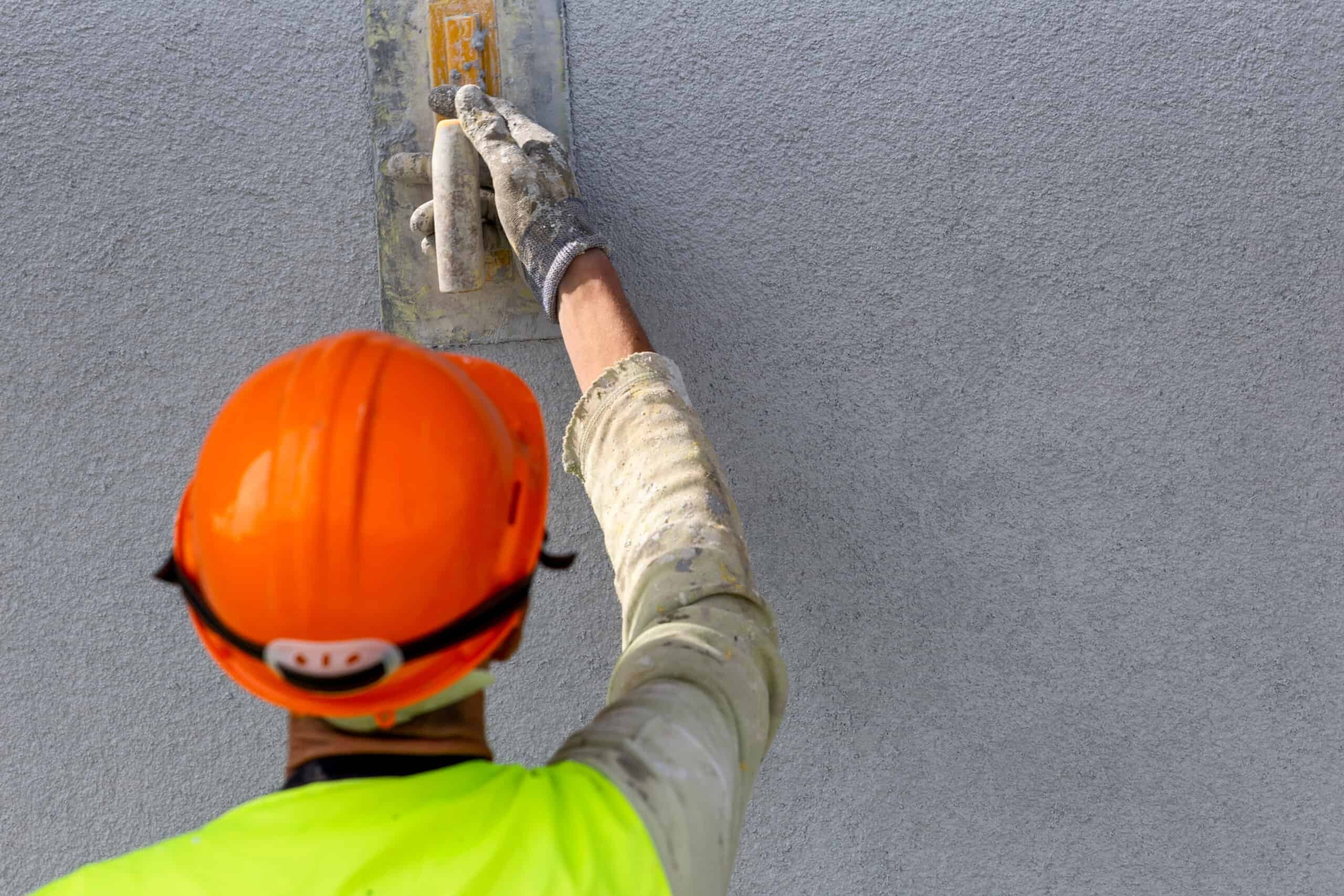 A roofer and a customer talking outside of a house.