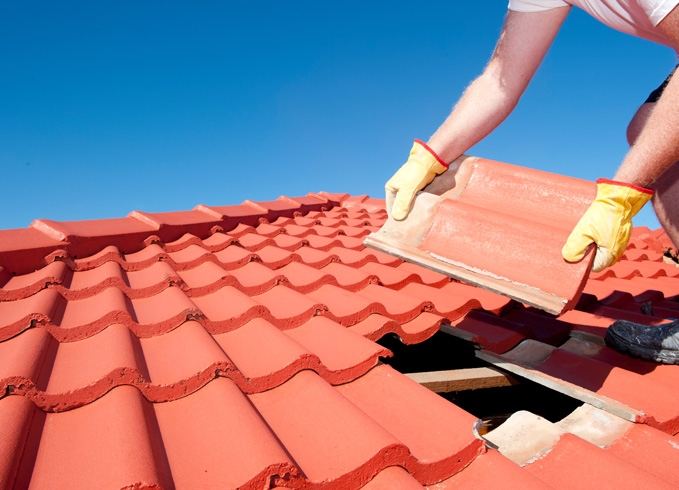 A roofer and a customer talking outside of a house.