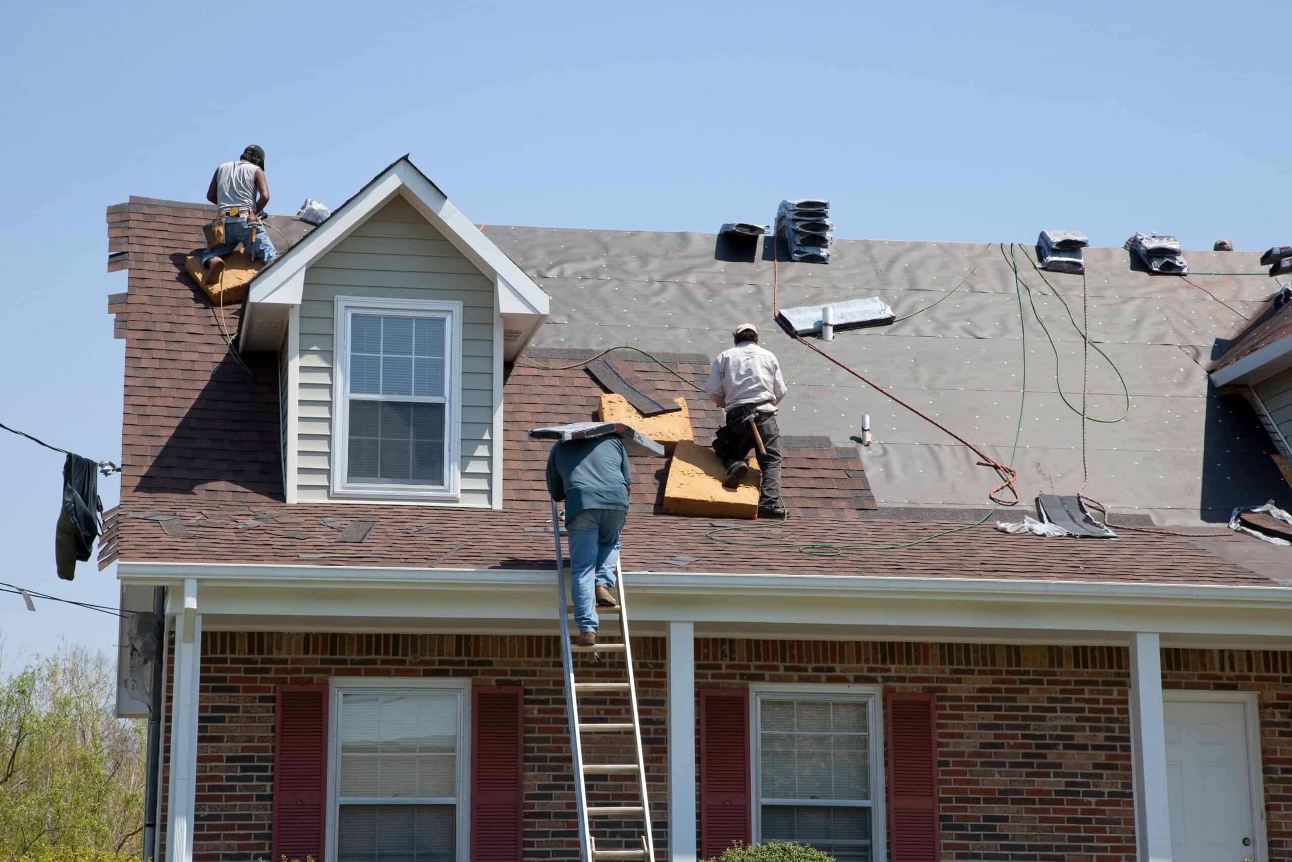 A roofer and a customer talking outside of a house.