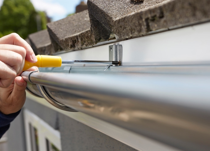 A roofer and a customer talking outside of a house.