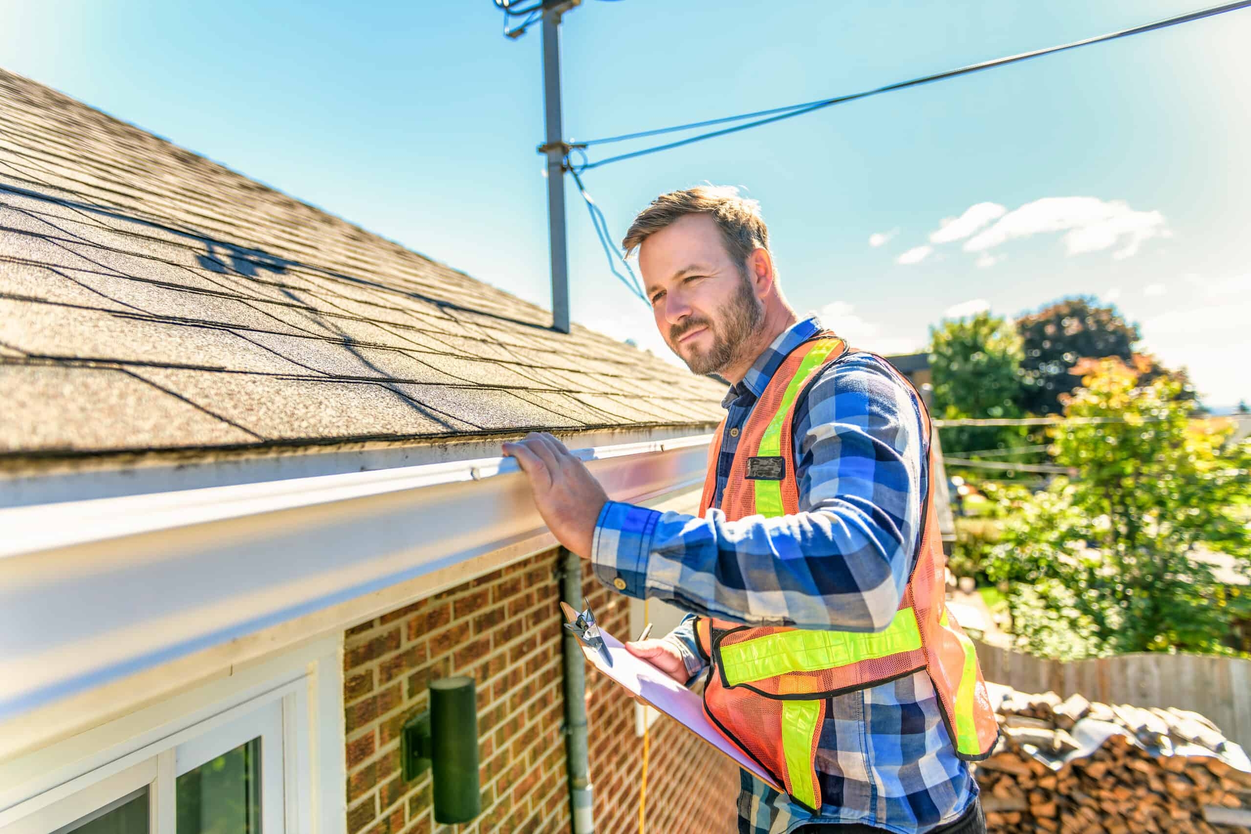 A roofer and a customer talking outside of a house.