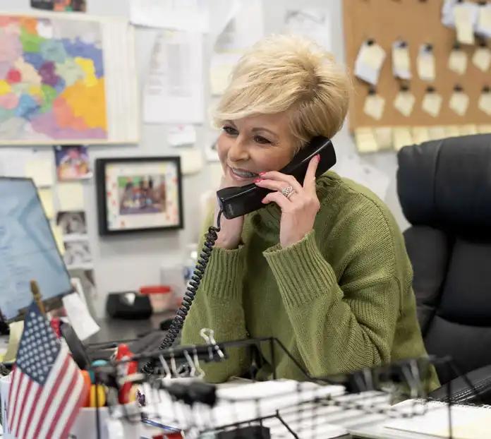 Woman sitting at a computer speaking on the phone